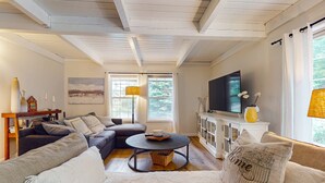 A living room with a sectional sofa, a round coffee table, and a flat-screen TV.