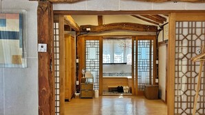 A traditional Japanese interior with wooden beams, sliding doors, and a central seating area. - Jukrokjungsa hanokstay  (Gurye)