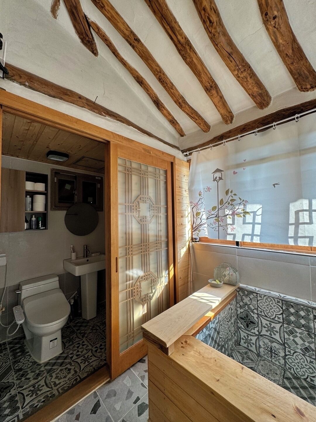 A bathroom with a toilet, sink, and a shower area.