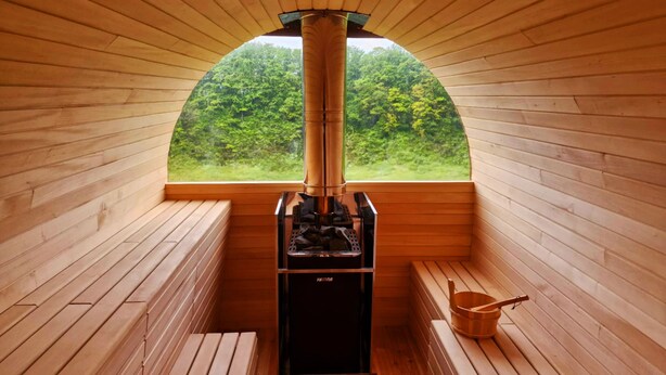 A sauna room with wooden walls and a large window. - Dwór Uradz (gmina Barwice)