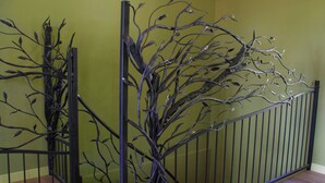 A staircase with a metal railing and a decorative tree sculpture. - Dwór Uradz (gmina Barwice)