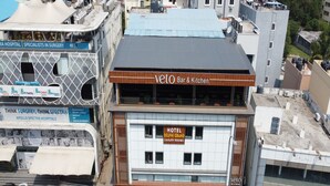 Un immeuble à plusieurs étages, sur lequel on peut voir une enseigne indiquant « Apollo Spectra Hospitals », un hôtel appelé « Delphi Grand » et un restaurant nommé « Pista House ».