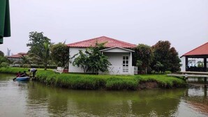 A house with a red roof, white exterior, and a white picket fence. - Crow Euro Inn Hotel and Resort (Dhamrai)