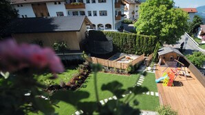 A residential area with a well-maintained garden, a wooden play structure, and a small wooden house. - Brixen-Plose! Your spacious family apartment directly in St. Andrä (Sankt Andrä)