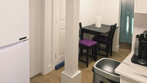 A compact kitchen with a white LG refrigerator, a dining table with purple chairs, and a coffee machine. - Private bedroom (2) in shared suit (Delta)
