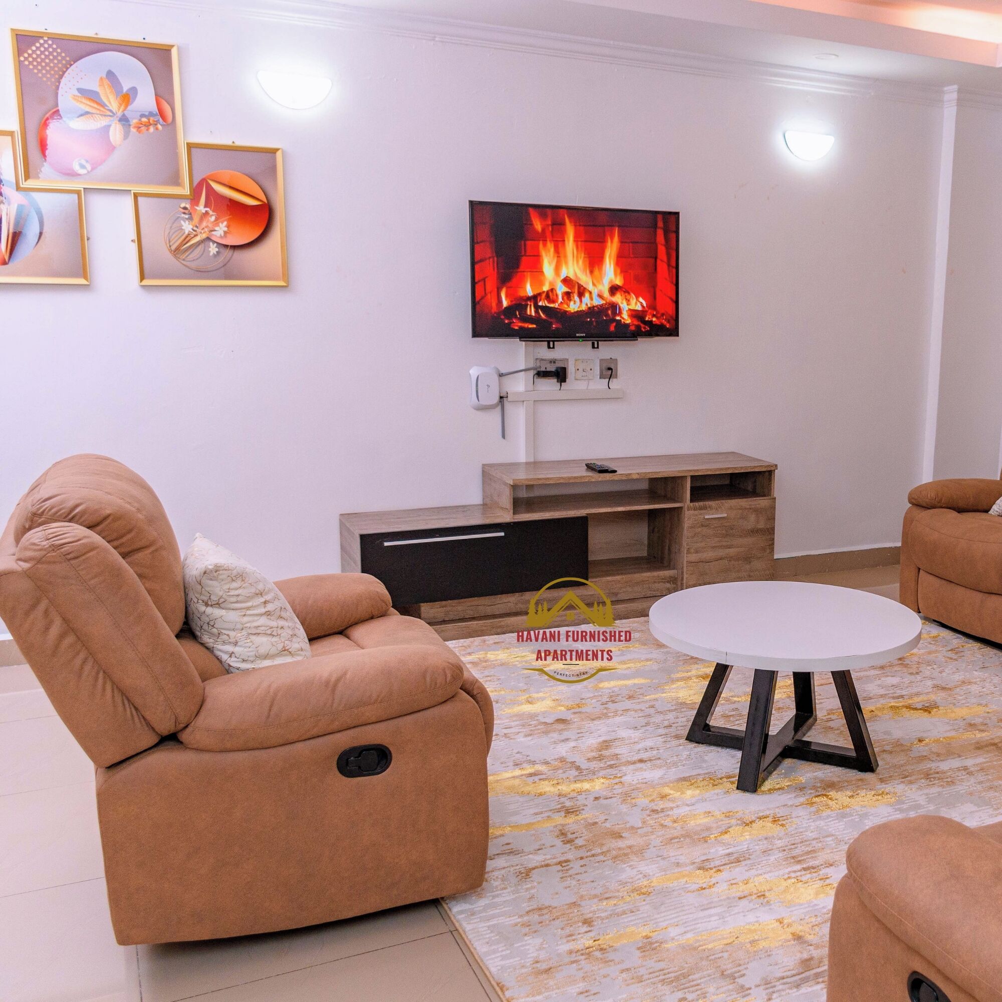 Ein Wohnzimmer mit einer Couch, einem Couchtisch und einem Flachbildfernseher, der einen Kamin zeigt.