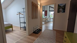 A room with a bed, a wooden wardrobe, a shoe rack, and a desk with a chair. - 2 room apartment touring view at the Kaiserberge motorcycle / bicycle garage (Waldstetten)