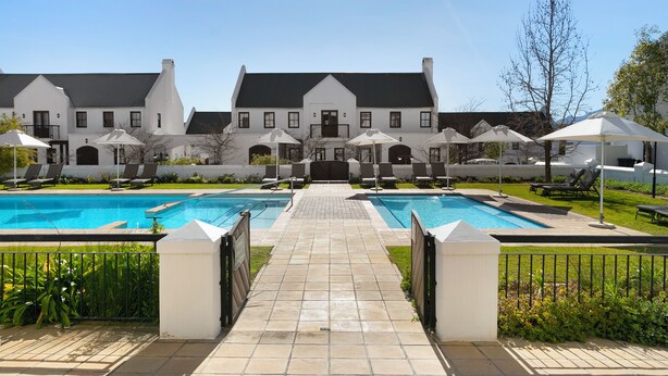 A large building with a swimming pool and outdoor seating area.