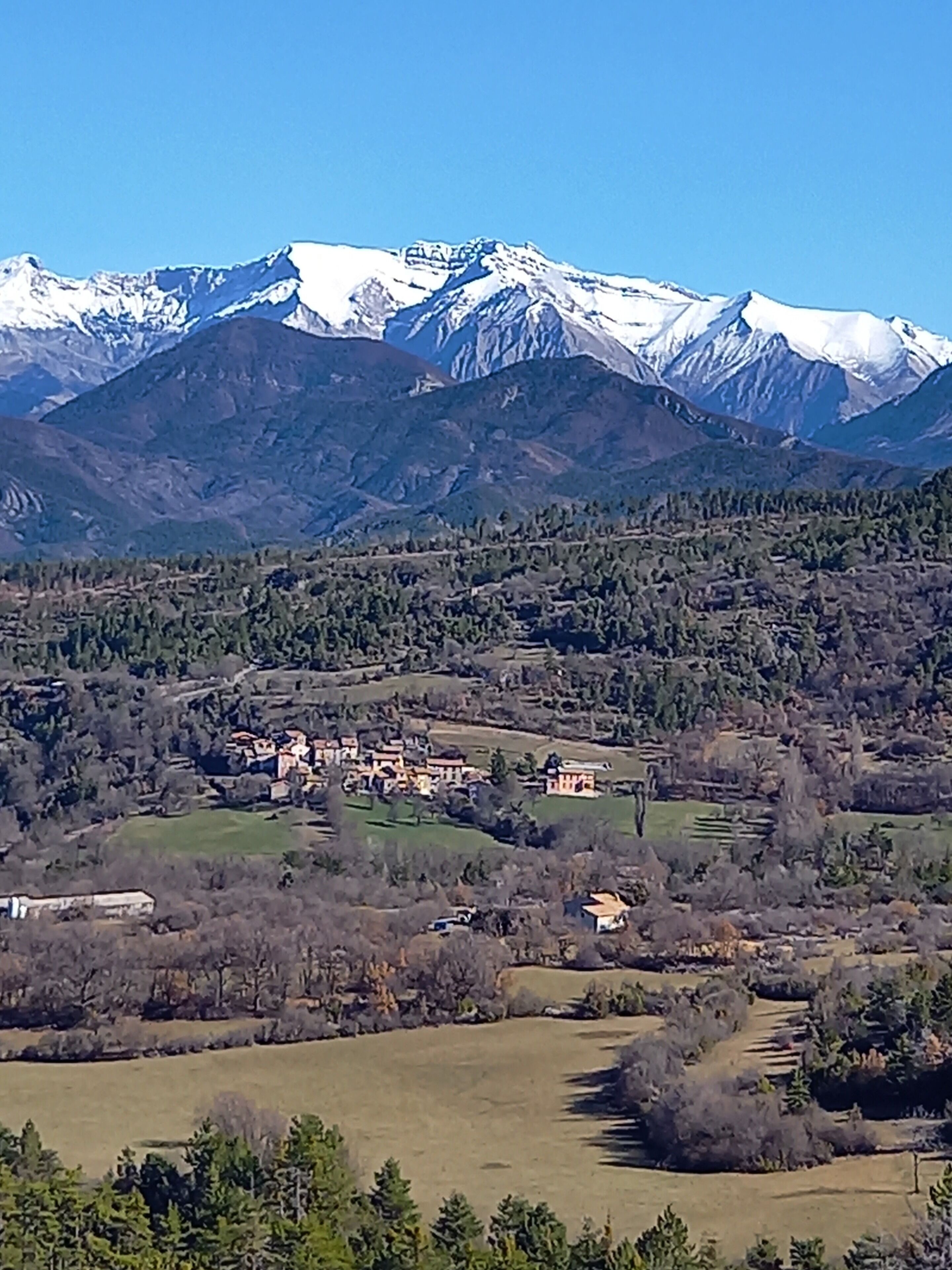 Un paysage montagneux avec un village niché au fond de la vallée.