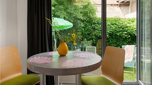 Een ronde tafel met een vaas en een groene stoel.