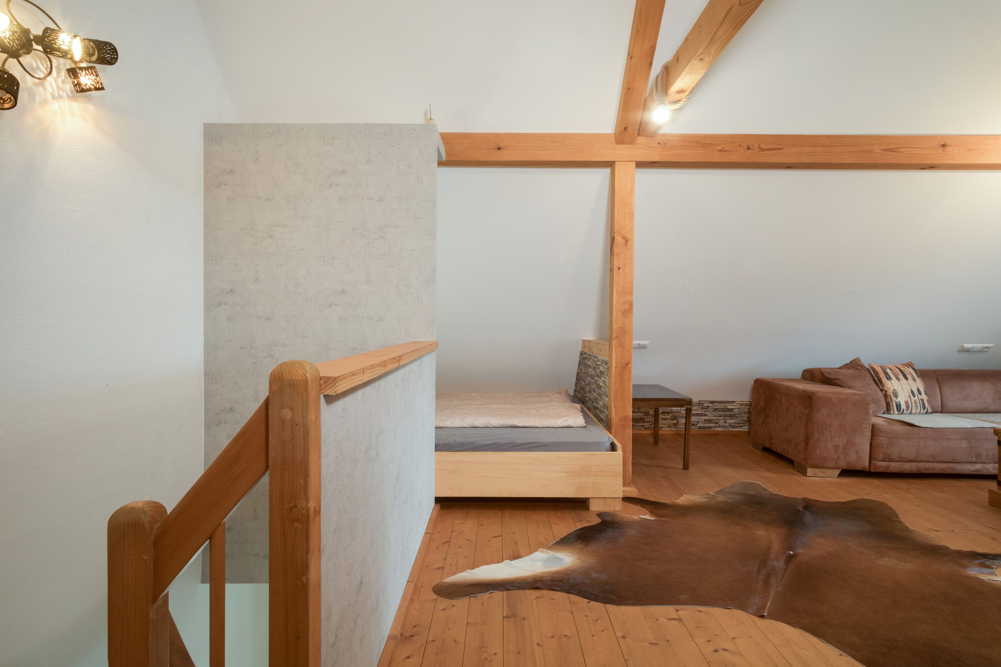 Ein modernes Interieur mit Hochbett, einer Ledersofa und einem einzigartigen Kuhfellteppich.