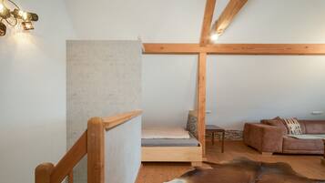 Ein modernes Interieur mit Hochbett, einer Ledersofa und einem einzigartigen Kuhfellteppich.