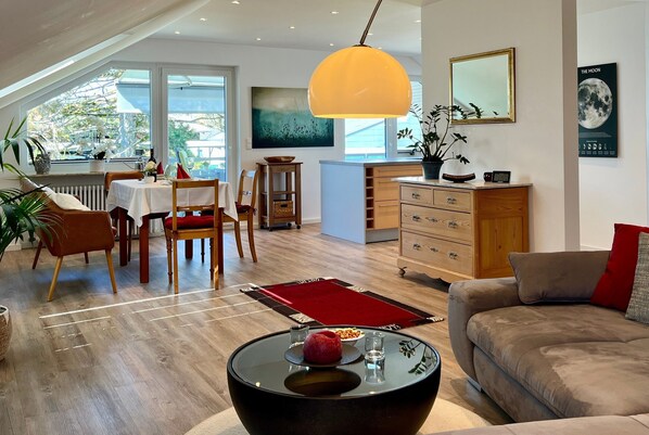 Uma sala moderna com sofá, mesa de jantar, cadeiras e mesa de centro.