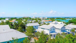 A coastal residential area with houses featuring blue and white exteriors, surrounded by greenery and a clear view of the ocean. - 🦩Book Me Baby! Wild Blue Yonder at Blue Mountain Beach🦩 (Seagrove Beach)