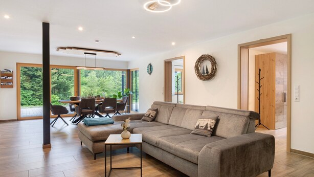 A modern living room with a sofa, coffee table, and dining area.
