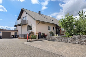 Ein zweistöckiges Haus mit Balkon, Garage und befestigter Auffahrt.
