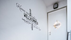 A staircase with grey steps and a wall with a welcome sign in German. - Apartment 'Wadee' with Lake View, Balcony and Wi-Fi (Radolfzell am Bodensee)