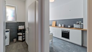 A modern kitchen with a built-in oven, microwave, and wooden countertop. - Holiday Apartment '1st Floor Left' with Balcony and Wi-Fi (Pforzheim)