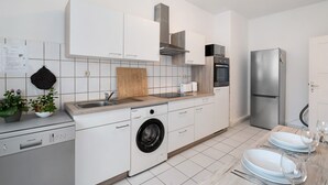 A modern kitchen with white cabinetry, a built-in washing machine, a stainless steel refrigerator, and a wooden countertop. - Apartment '2nd Floor Left' with Wi-Fi (Pforzheim)