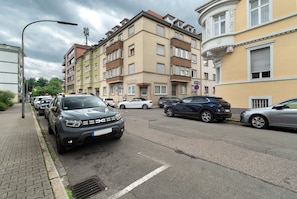 Un edificio residencial de varios pisos con automóviles estacionados en la calle.