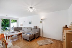 Un salon moderne avec un canapé, une table basse et un lampadaire.