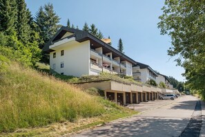 A modern building with multiple balconies, a parking area, and a hillside setting. - Apartment 'Mental Fit,  11, Todtmoos' with Mountain View, Private Terrace and Wi-Fi (Todtmoos)