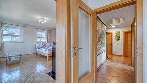 Una habitación amplia con una cama, una mesita y una puerta que da a otra estancia.