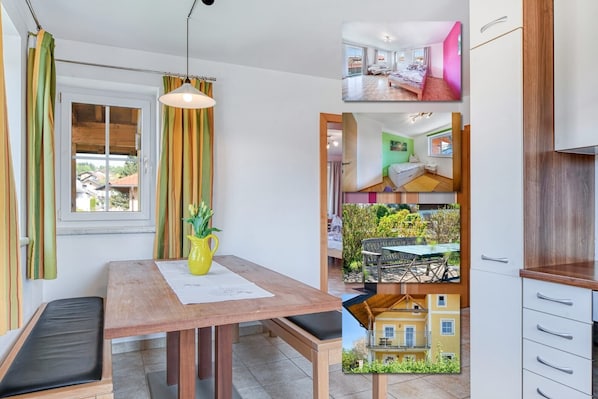 A modern interior with a wooden dining table, bench, and yellow pitcher on a mat.