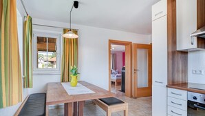 Una cocina moderna con armarios blancos, encimera de madera y horno empotrado.