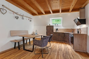 A modern kitchen with wooden cabinets, a built-in oven, and a window.