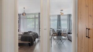 A modern hotel room with a bed, a dining table, and a sofa. - Holiday Apartment 'Loft Style' with Balcony and Wi-Fi (Schluchsee)