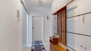 Ein Flur mit einem Holzschrank, einem Spiegel und einer Tür.