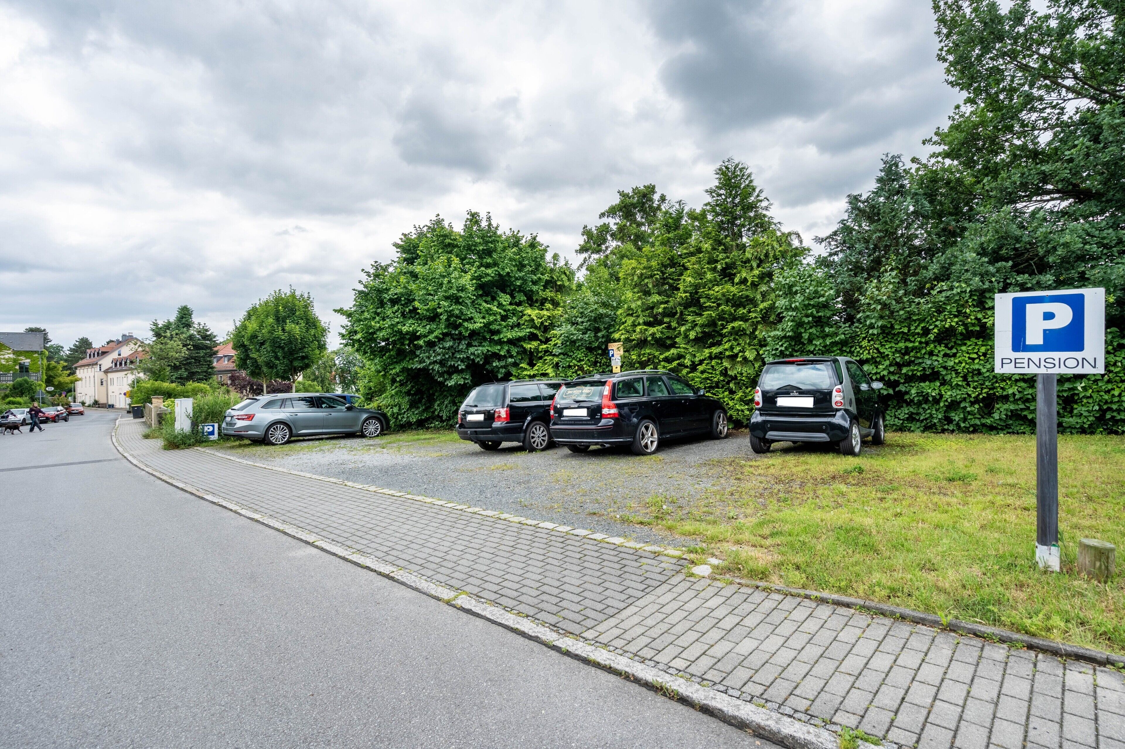 Ein Parkplatz mit einem Schild, das ihn als Parkplatz einer Pension kennzeichnet.