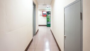 A hallway with a vending machine and a door at the end. - Hotel O Melintang Hotel (Hutan Melintang)