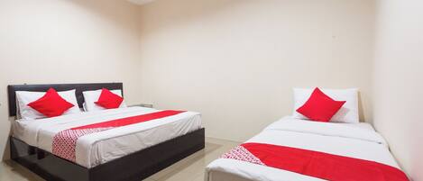 Habitación de hotel con dos camas, cada una con ropa de cama blanca y detalles en rojo, y un cabecero negro.