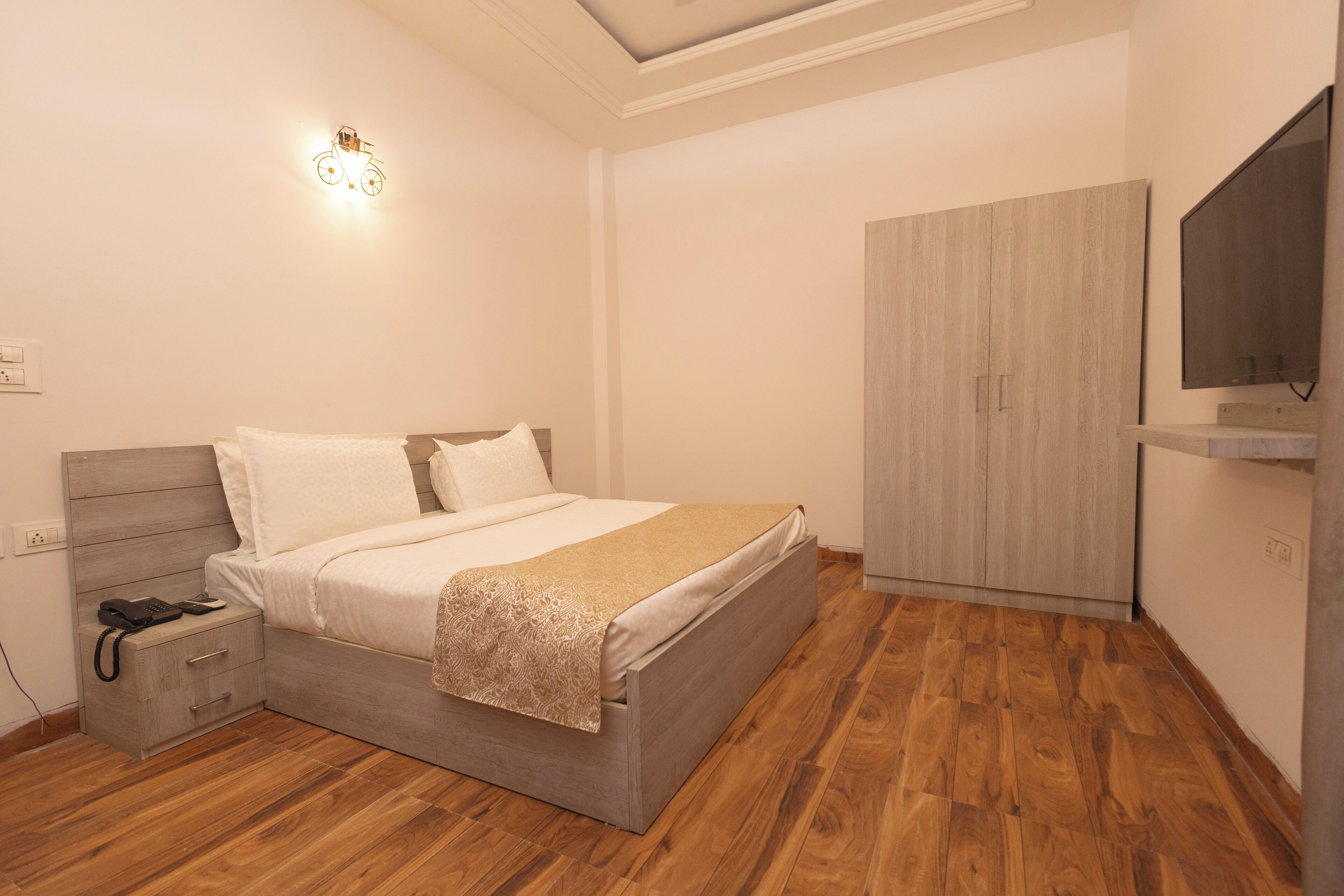 A bedroom with a bed, bedside table, and a wardrobe.