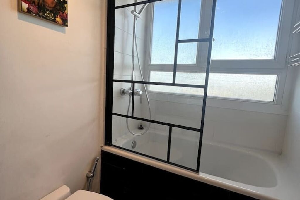 Une salle de bain avec une douche à parois de verre, une baignoire et des toilettes.