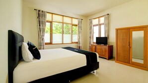 A bedroom with a bed, a television on a wooden cabinet, and a wardrobe. - Hotel O Villa Beringin Puncak (Cisarua)
