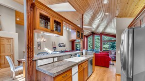 A modern kitchen with wooden cabinetry, granite countertops, and a stainless steel refrigerator. - Modern Retreat in Truckee with A/C & Game Room (Truckee)