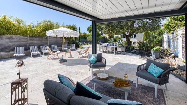 A covered patio with outdoor furniture, a dining table, and a pergola. - Gorgeous home in Royan (Royan)
