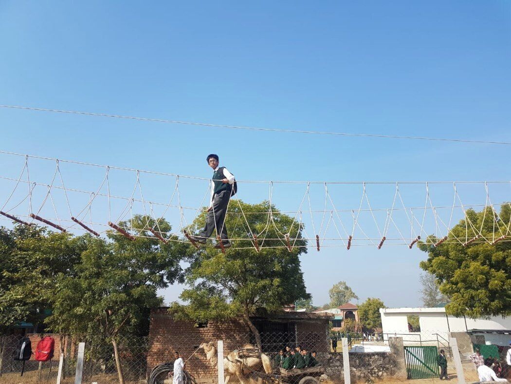 A person walking on a rope bridge.