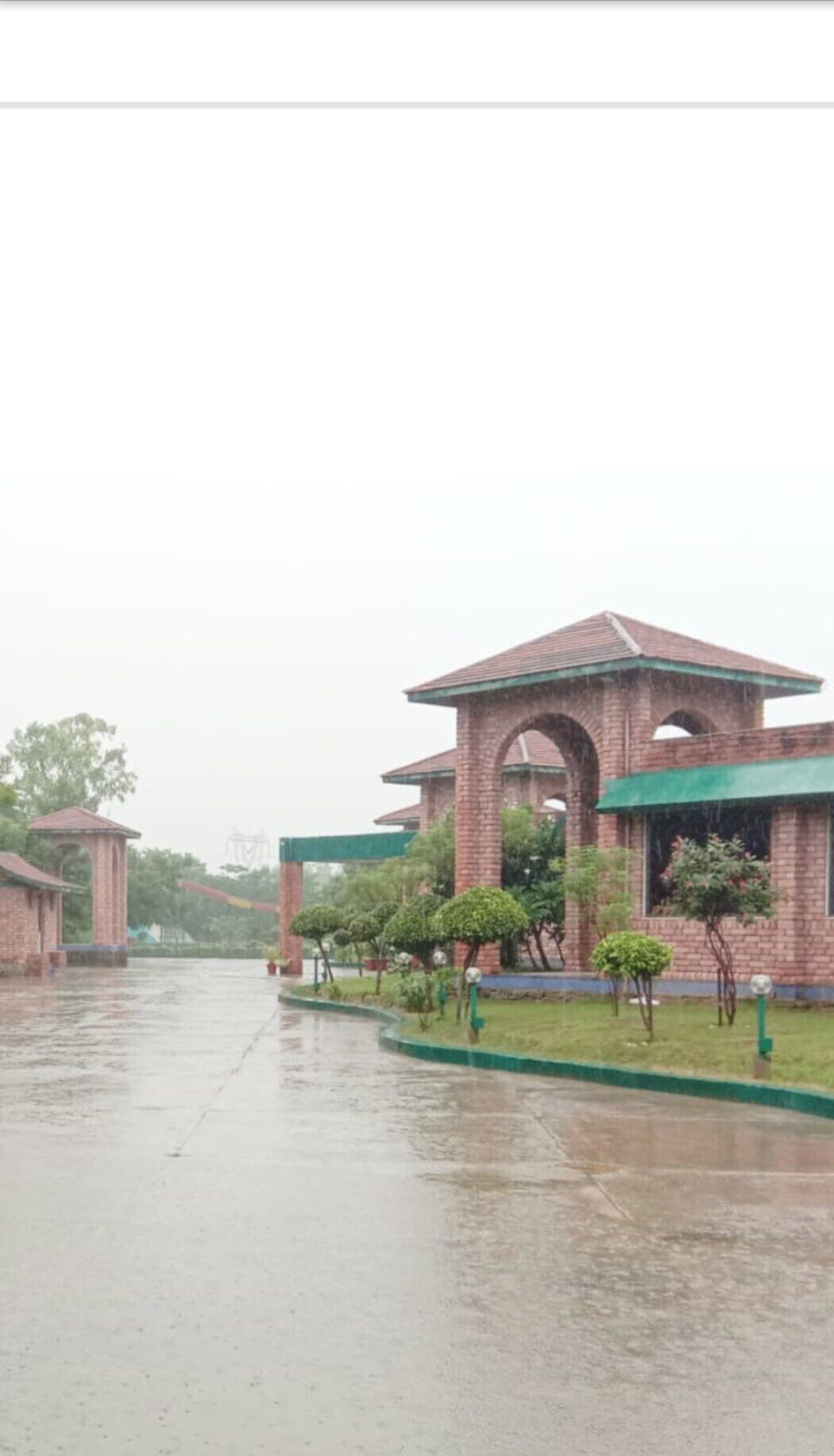 Um edifício de tijolos com telhado verde e entrada em arco.