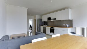 Een moderne keuken met witte kasten, een houten aanrecht en een ingebouwde oven.