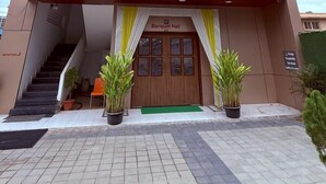 A hotel with a modern facade, a sign for the Banquet Hall, and a reception area with a staircase. - Hotel Aaditya Inn Tathawade (Paud)