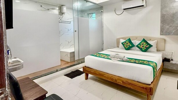 A modern hotel room with a bed, a desk, and a chair. - Hotel Aaditya Inn Tathawade (Paud)