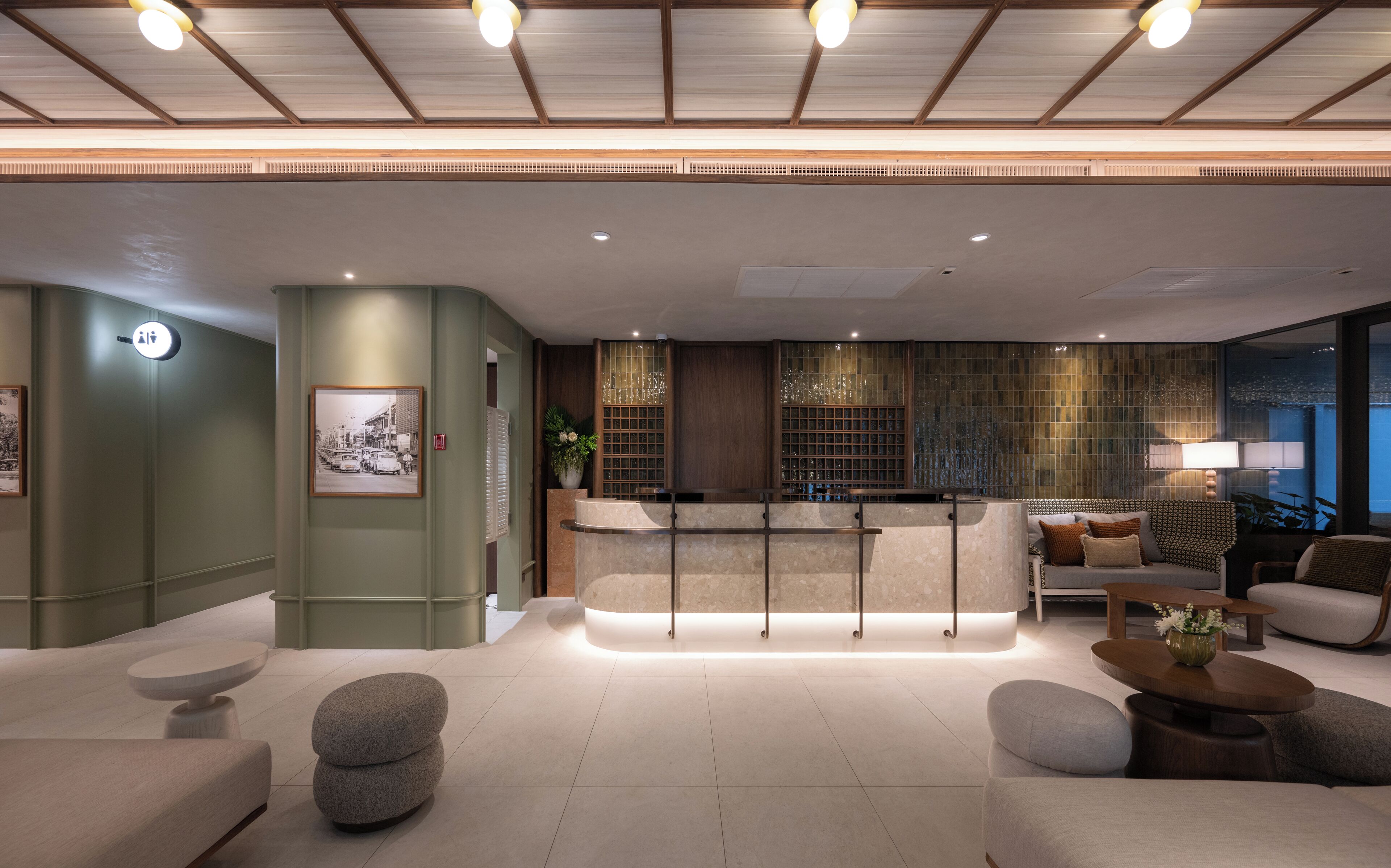 A modern lobby with a reception desk, seating area, and a large window offering a view.