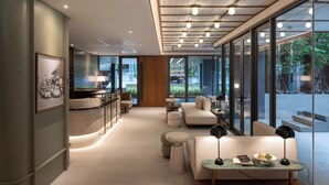 A modern interior with a kitchen area, seating, and large windows. - The Moment (Bangkok)