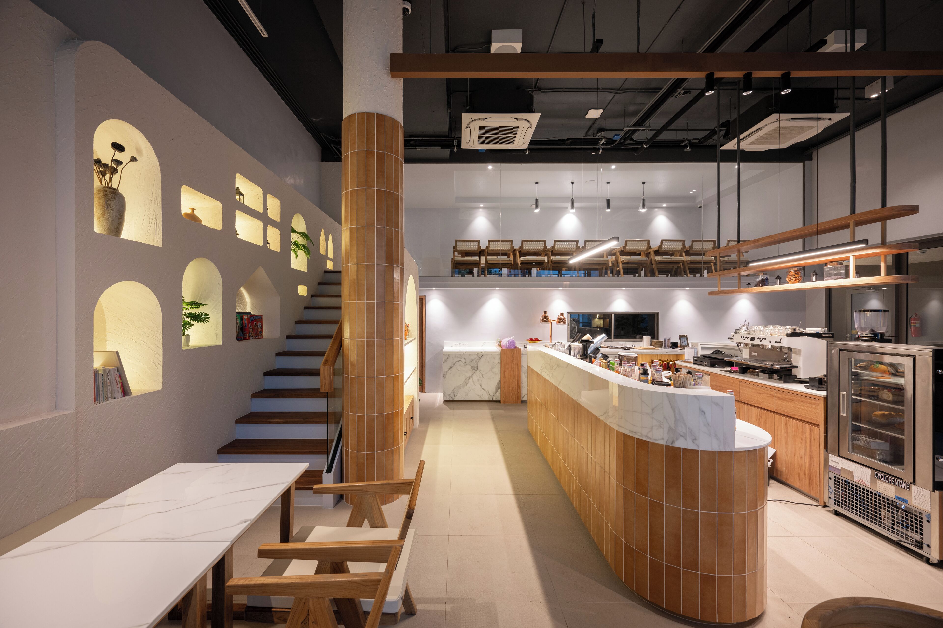 A modern kitchen with a central island, wooden accents, and a marble backsplash.