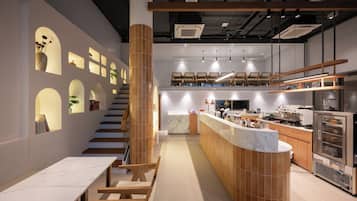 A modern kitchen with a central island, wooden accents, and a marble backsplash.