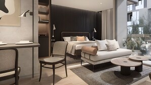 A modern hotel room with a bed, a sofa, a desk, and a chair. There are two bedside tables and a window with a view of the outside. - The Moment (Bangkok)